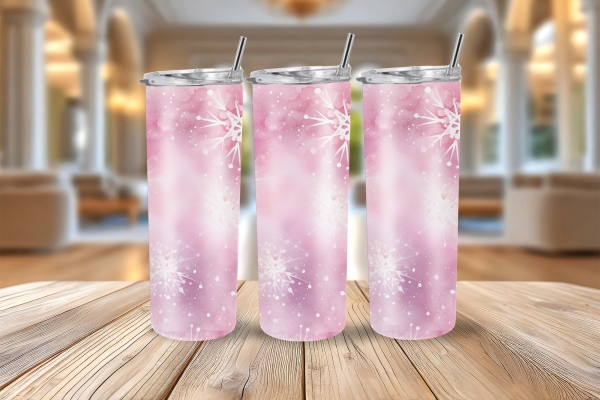 Drei rosa Thermobecher mit Schneeflockenmotiv, je 590 ml Fassungsvermögen, auf einem Holztisch in einem elegant eingerichteten Raum mit großen Fenstern und weicher Beleuchtung.